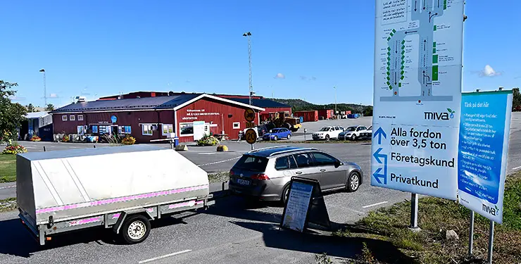 En bild med släpvagn vid orienteringstavla med Må återvinningscentral i bakgrunden