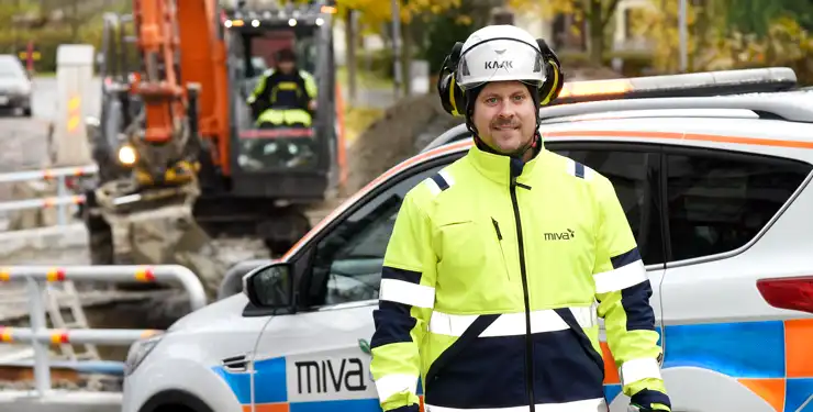 En man som står bredvid en vit SUV.
